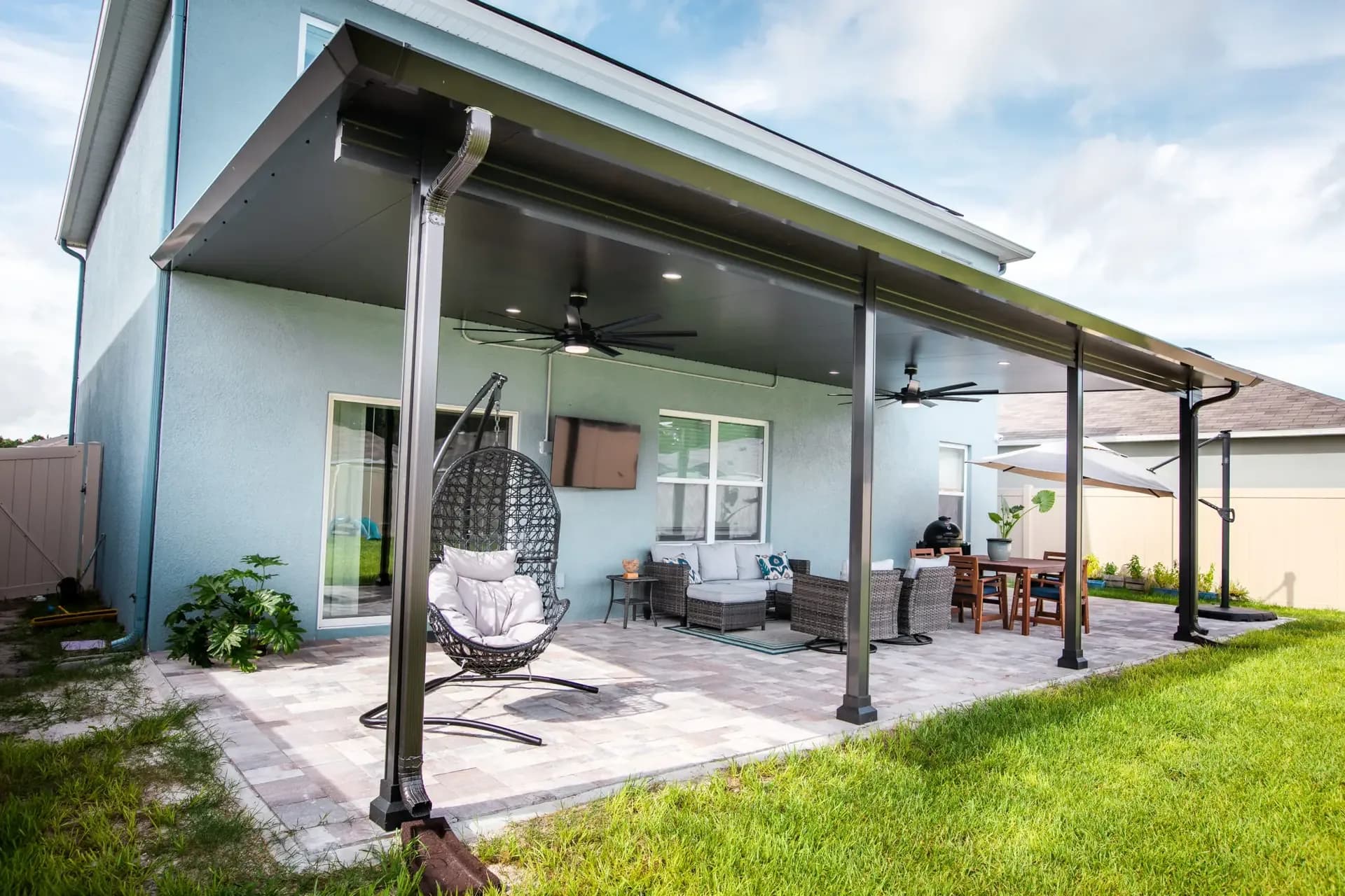 Insulated aluminum patio cover over a paver patio with a hanging chair