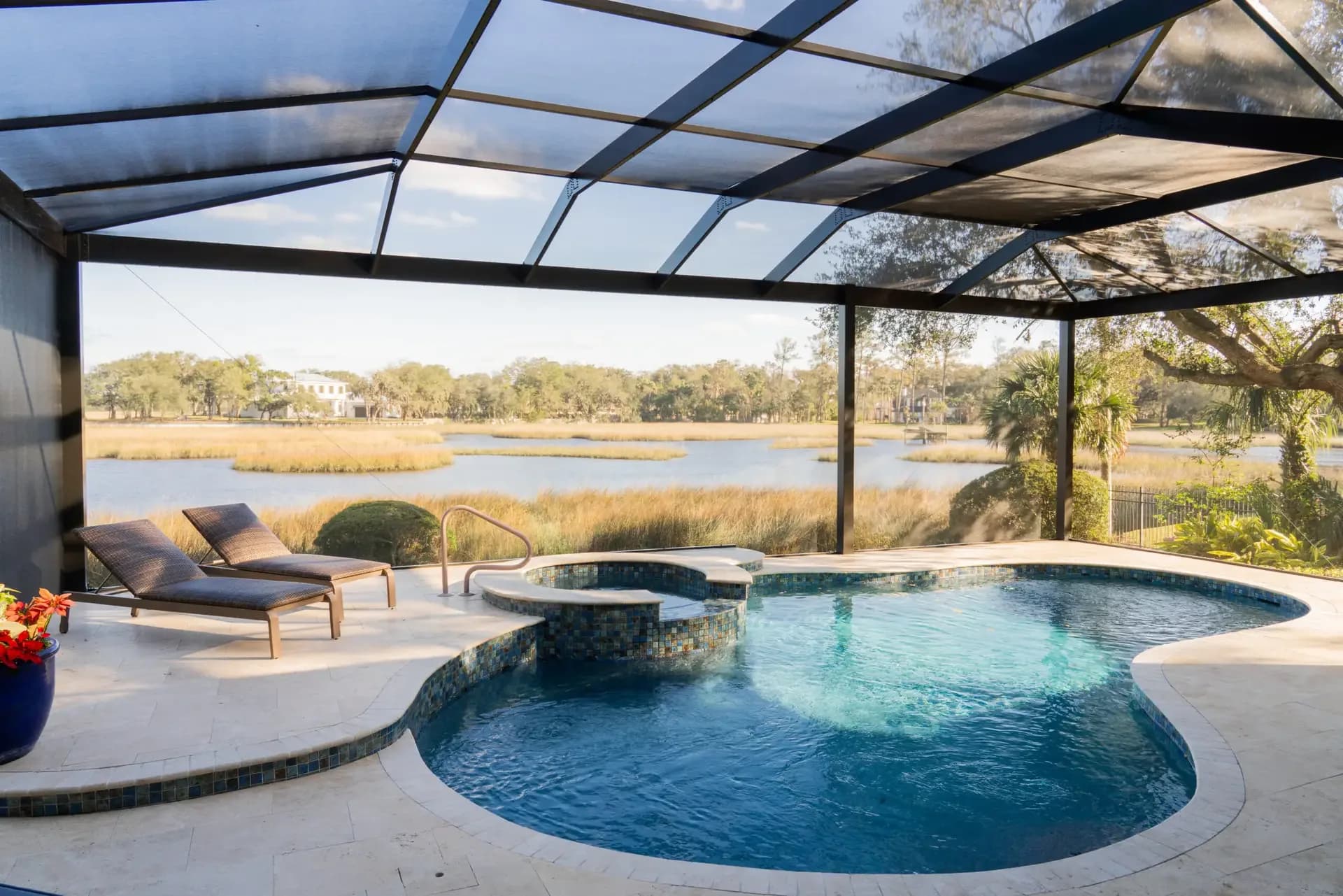Enclosed pool with loungers overlooking the marsh at sunset