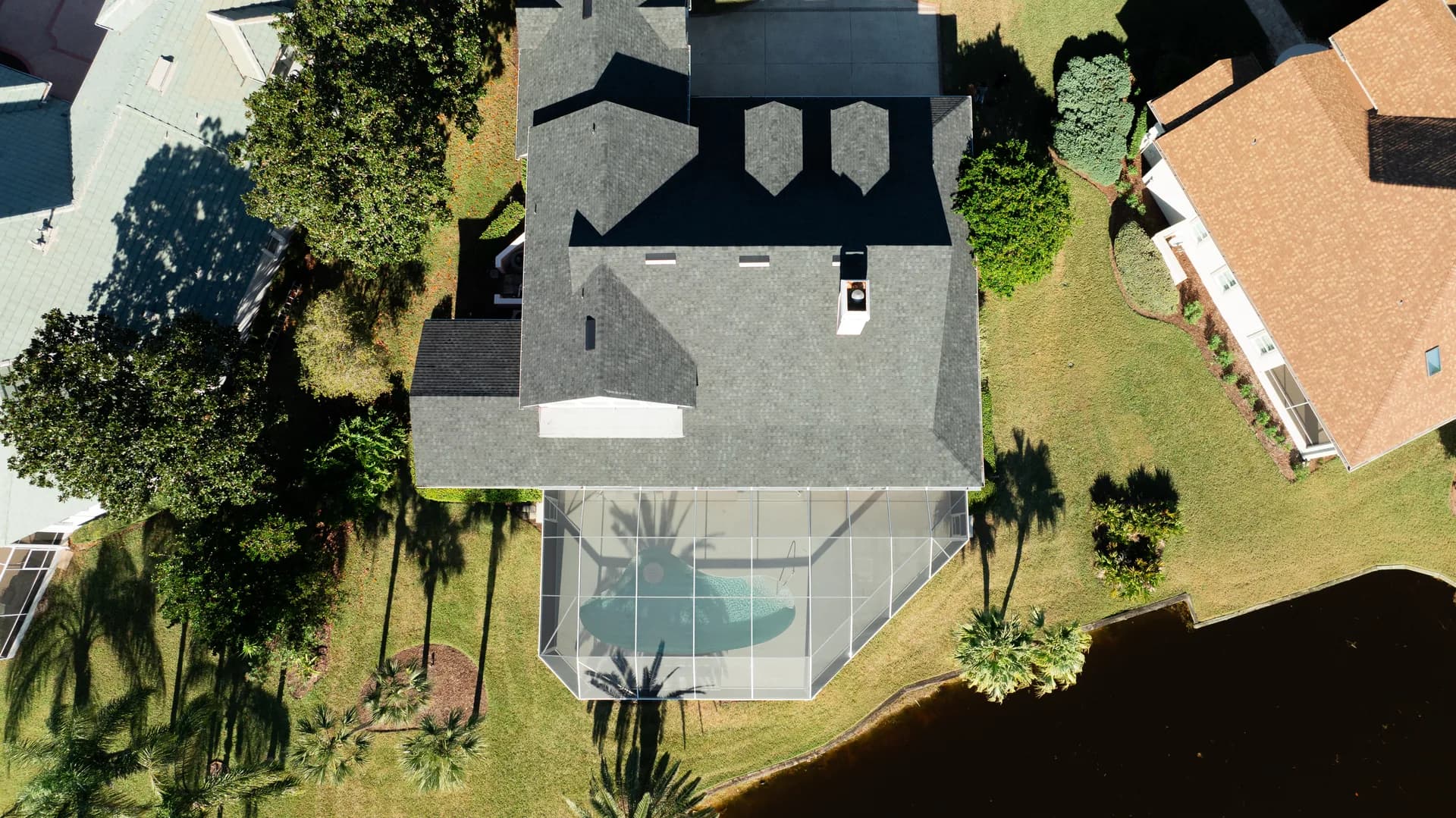 Top-down aerial view of a home with a screened pool enclosure