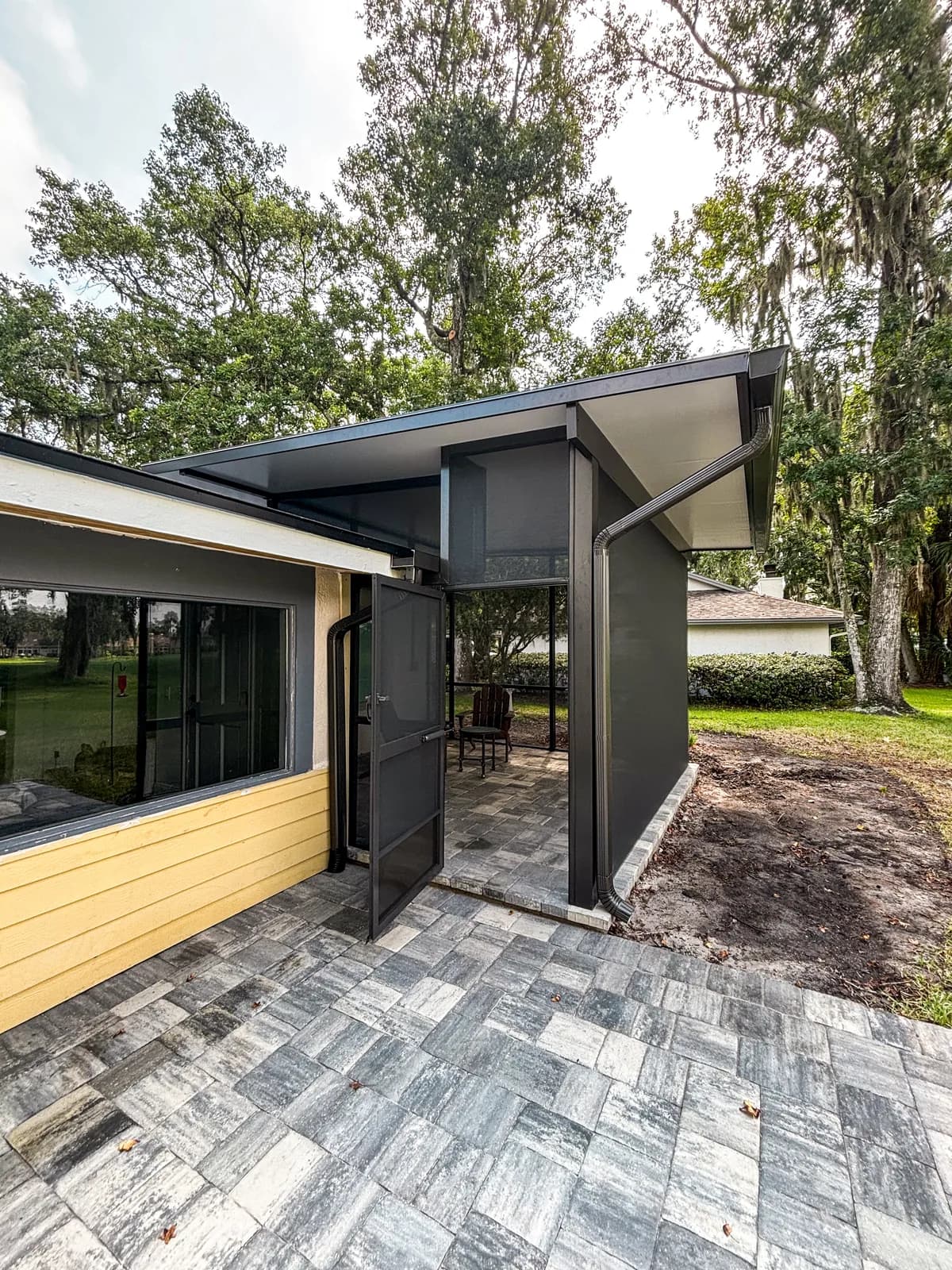 Modern screened porch with a gray paver patio by Screen'D In